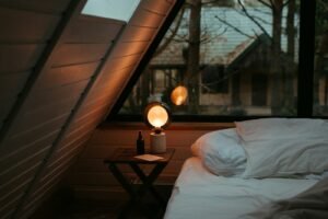 Small bedroom with a low platform bed under a window, styled for a cozy, luxurious look