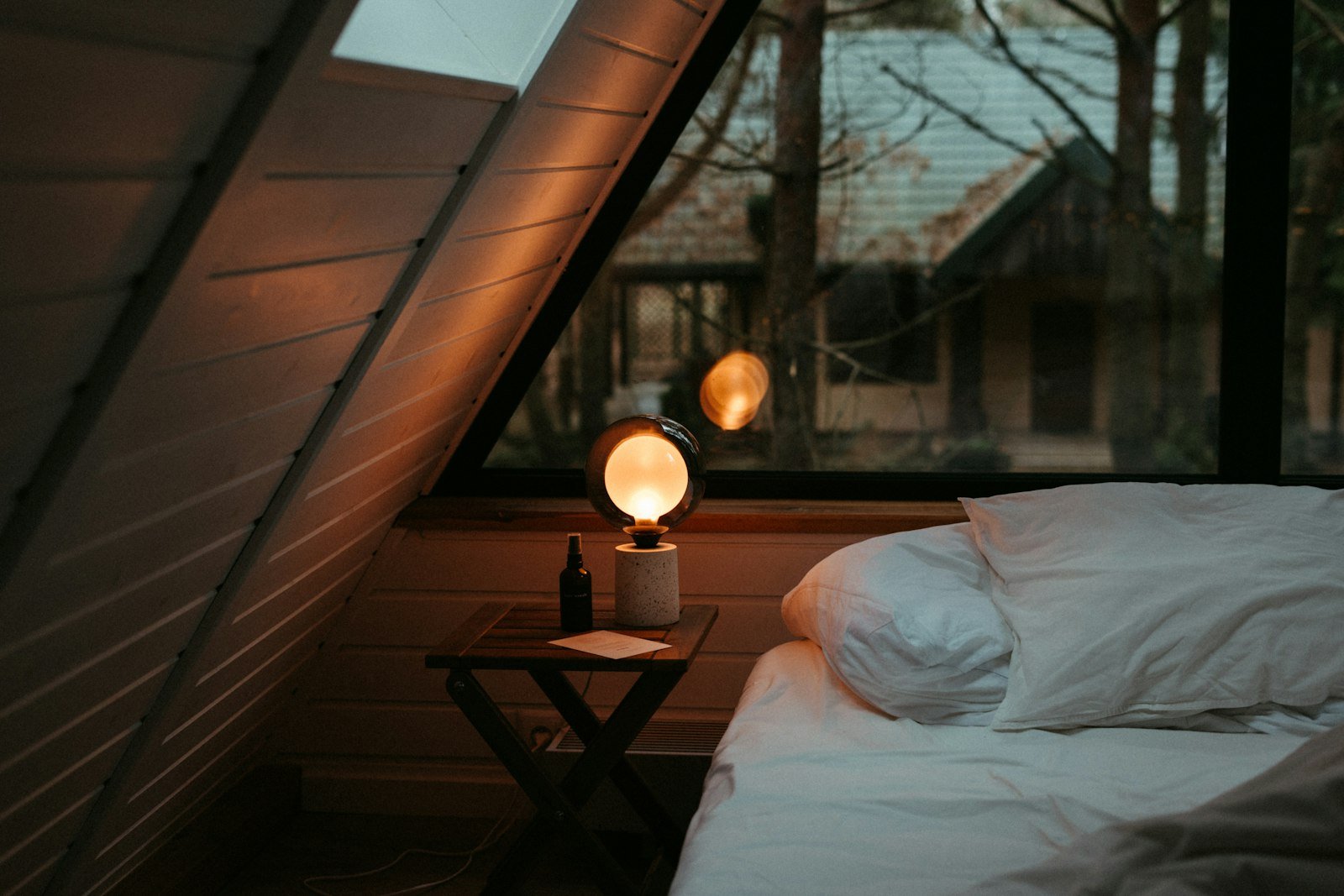 Small bedroom with a low platform bed under a window, styled for a cozy, luxurious look